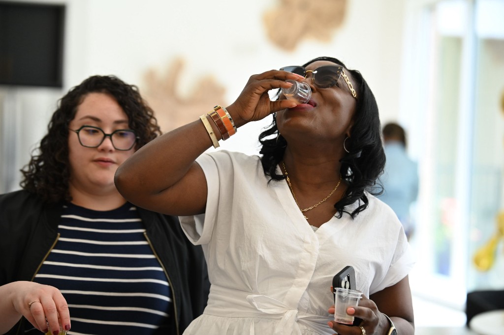 Customer sampling Prime Rise at an indoor event